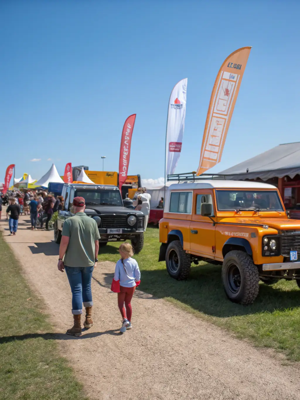 A vibrant off-roading show with various vehicles on display and attendees exploring.